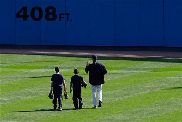Andy Petitte and his sons walk across the outfield to the bullpen before today's game against the Orioles.